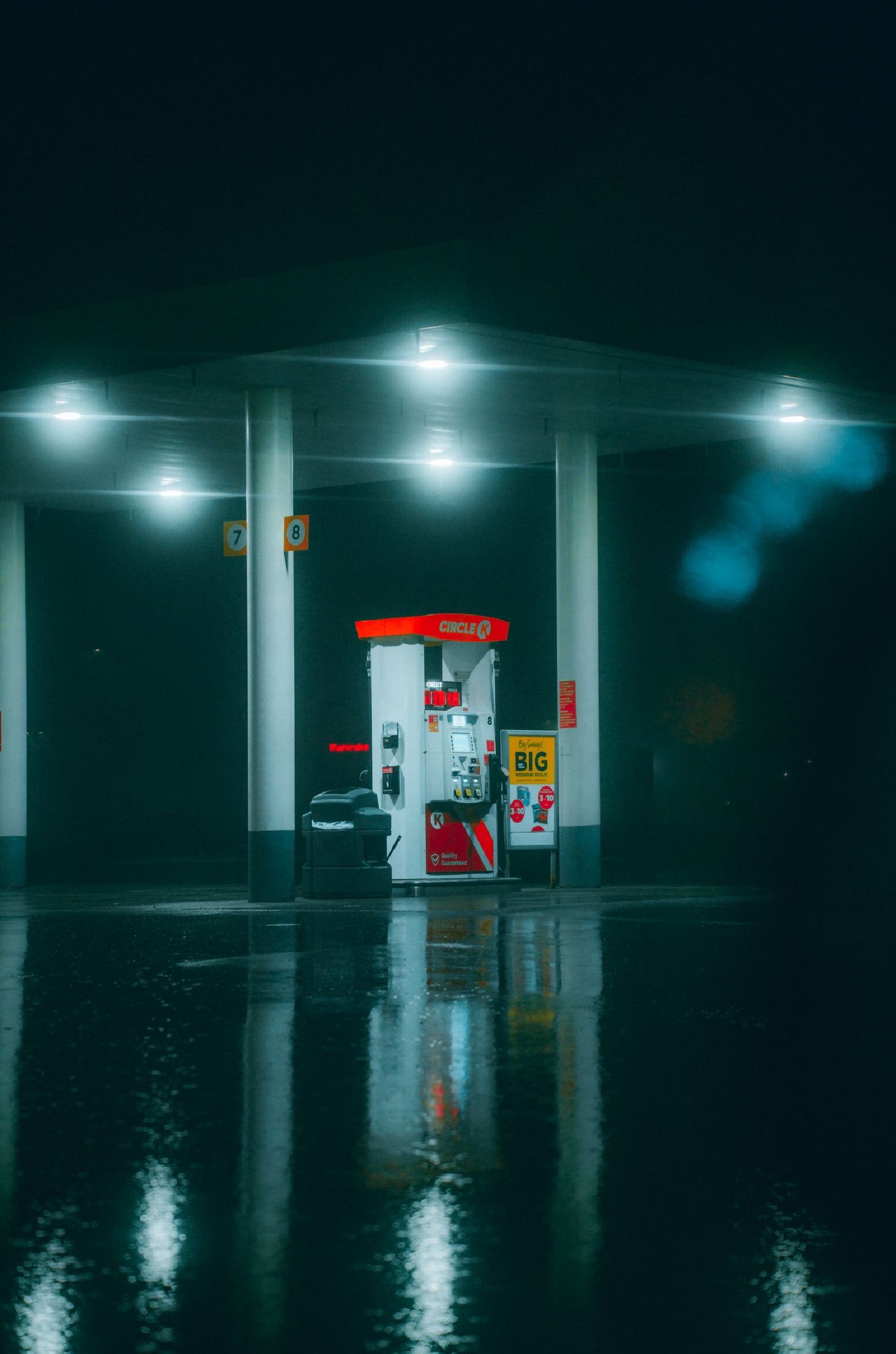 Petrol pump at a service station on a rainy night