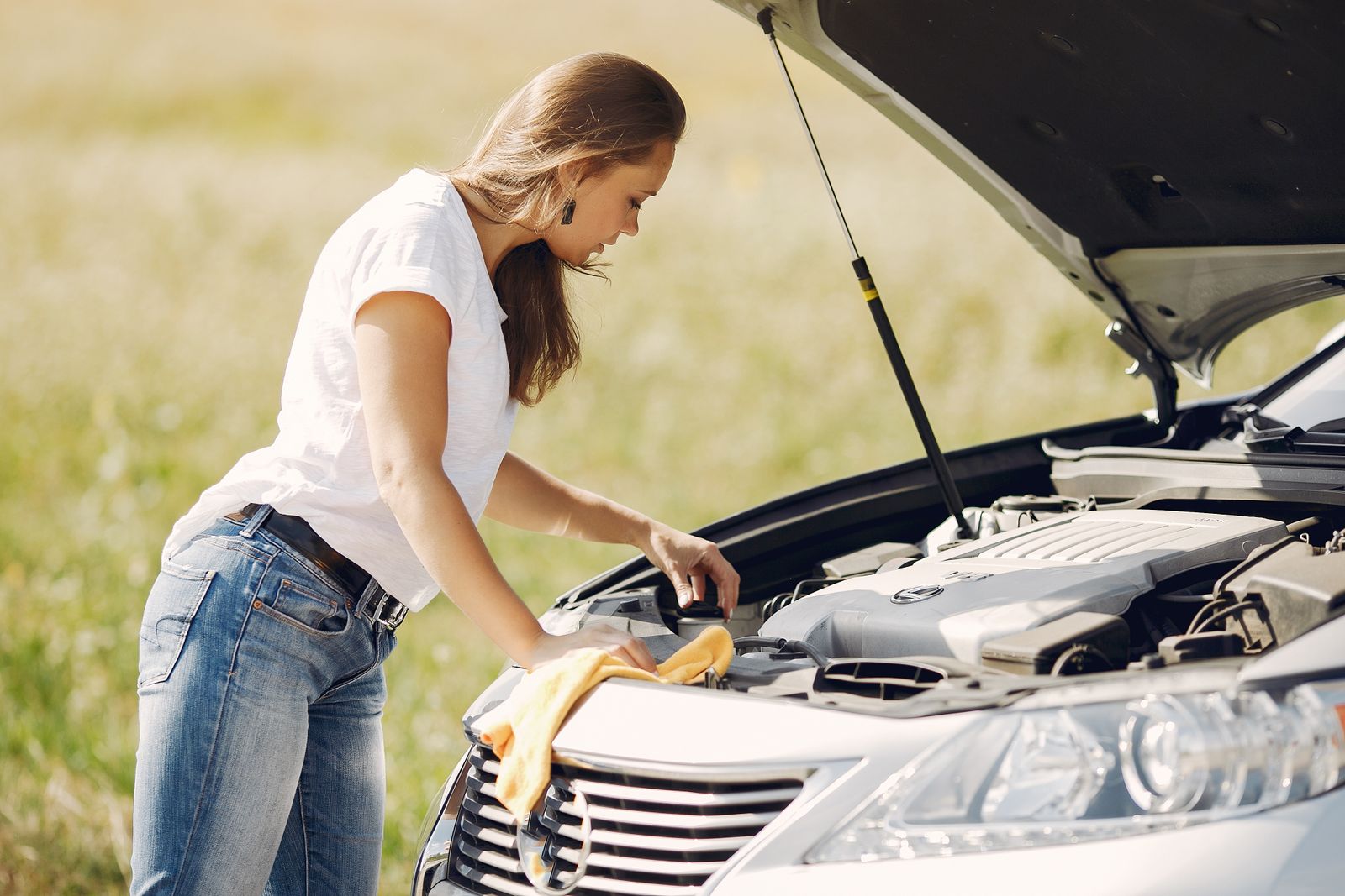 Driver checking the engine of her car at the roadside