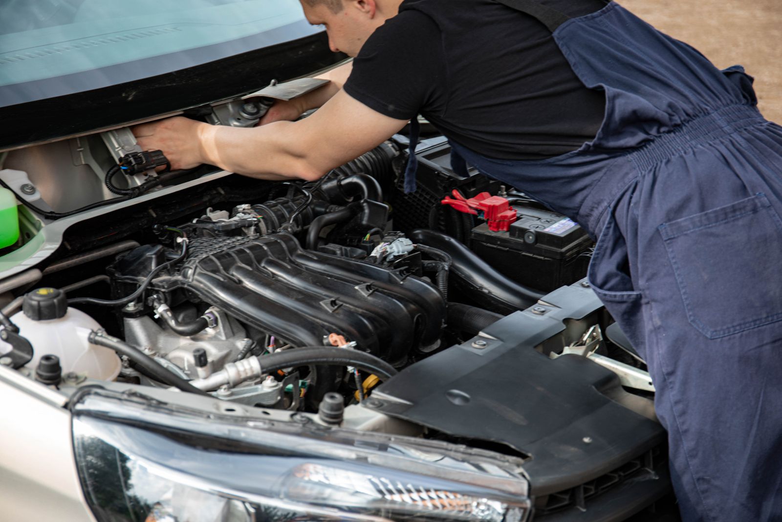 Mechanic inspecting a car engine with the bonnet open
