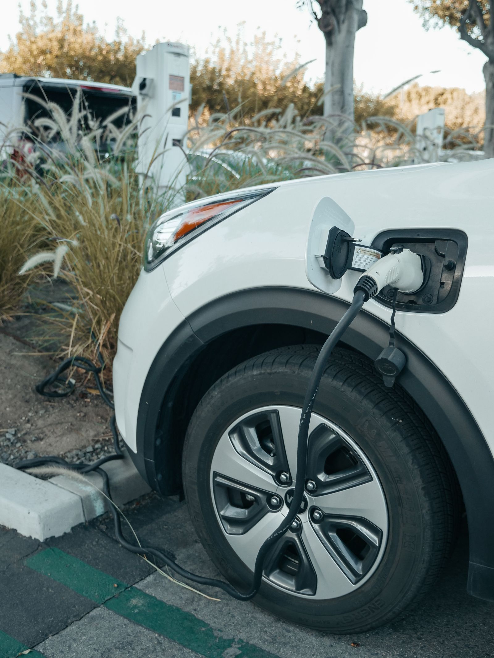 White plug-in hybrid car connected to a charging cable